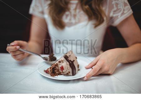 Midsection of woman with desert in plate at restaurant