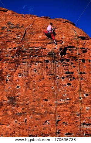 Rock climbing on red sandstone for sport recreation challenge and fun