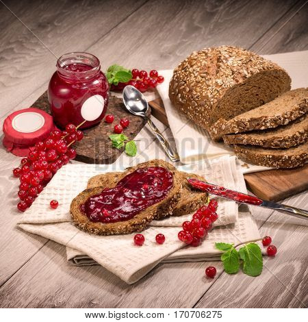 Jam currant bread composition on a wooden background