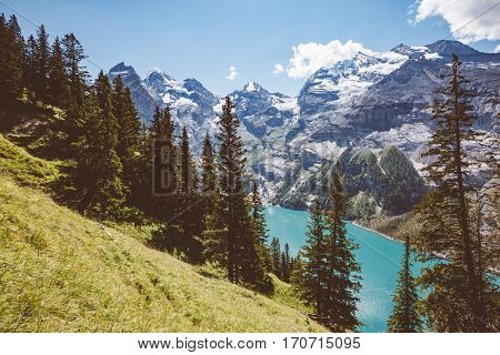 Glacier pond Oeschinensee. Popular tourist attraction. Picturesque and gorgeous scene. Location Swiss alps, Kandersteg, Bernese Oberland, Europe. Vintage effect. Instagram filtered. Beauty world.
