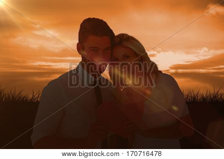 Attractive young couple holding pink heart against a couldy day