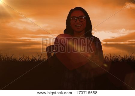 Asian woman holding paper heart against a couldy day