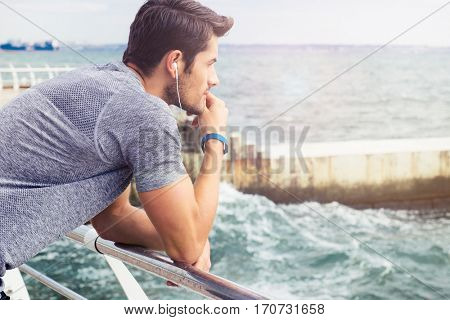Side view portrait of a sports man looking at sea ourdoors