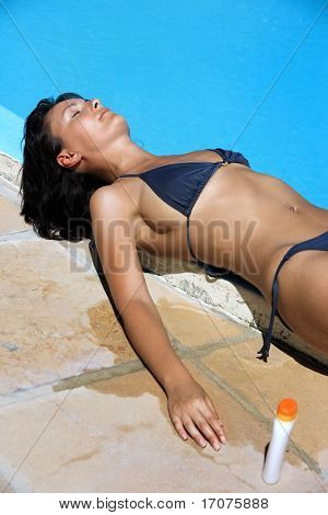 Young beautiful caucasian brunette Woman entspannen oder schlafen, nahe einem Schwimmbecken, die immer von gegerbt