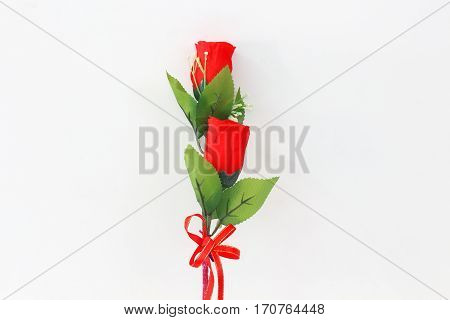 Plastic red roses on a white background.