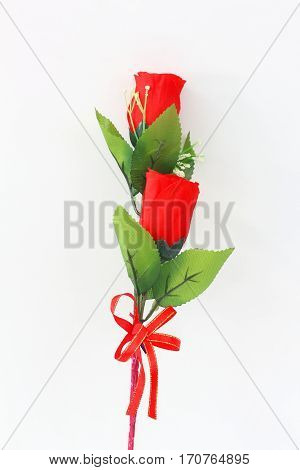 Plastic red roses on a white background.
