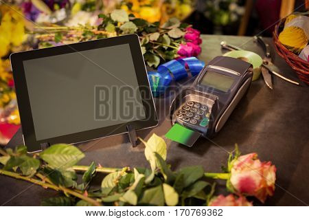Close-up of Digital tablet and credit card terminal on the table at flower shop