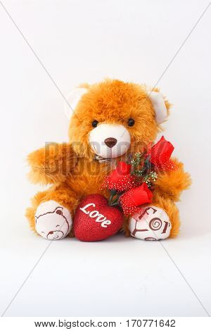 Brown teddy bears and red roses on a white background.