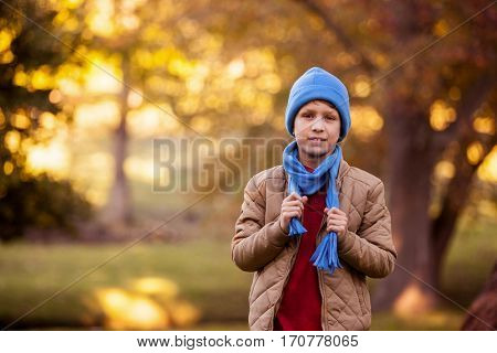 Portrait of boy holding scarf while standing at aprk