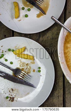 Overhead shot of an empty plate with leftovers from a meal on a rustic wooden backround