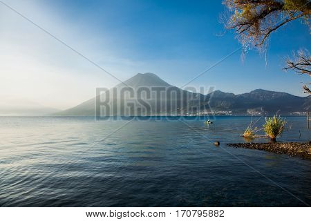 Fisherman and morning fog over Atitlan lake in Guatemala. Central America.