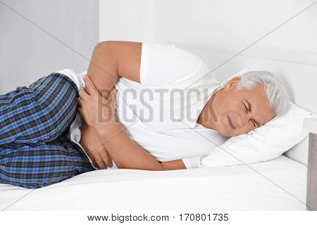Senior gentleman suffering from pain in bedroom