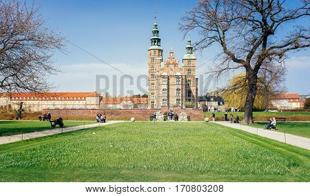 Rosenborg Castle used by Danish regents as a royal residence view from Rosenborg palace garden with green grass anb blue sunny sky at a spring time in Copenhagen, famous Denmark landmark.