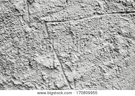 closeup of a rustic and cracked off-white plastered wall