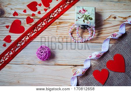 Hearts flowers ribbons on a wooden light background
