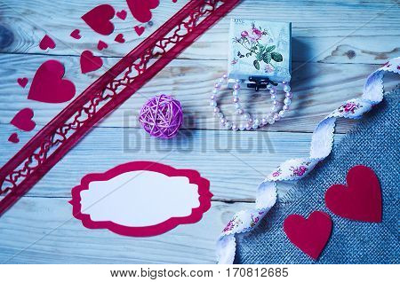 Hearts flowers ribbons on a wooden light background