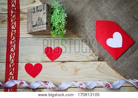 Hearts flowers ribbons on a wooden light background