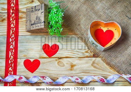 Hearts flowers ribbons on a wooden light background