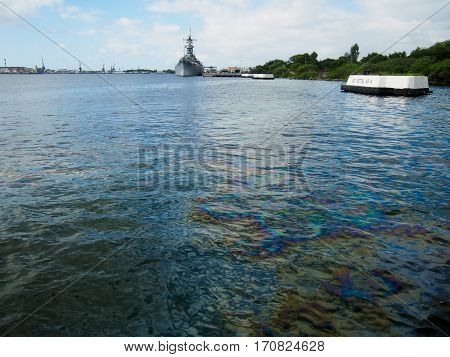 Oil still floats on the top of the water where it was spilled when the USS Arizona was sunk during the attack on Pearl Harbor Oahu Hawaii.