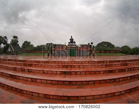 Red brick platform with statue of King Ramkhamhaeng at Sukhothai Historic Park Thailand.