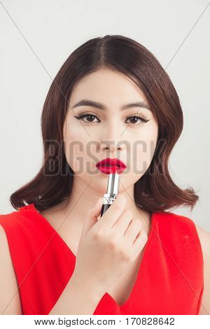 Young asian sexy woman with dark hair using red lipstick