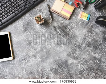 Top view of Keybroad with tablet, headphone, notebook, cactus and Office supplies on Grunge gray background Free space for text