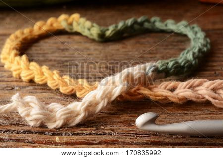A low angle image of crochet yarn and a single crochet hook.