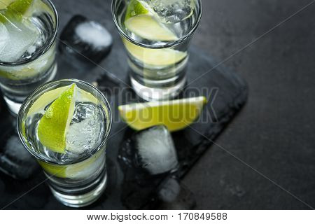 Vodka lime ice drink cocktail black background. Strong drink