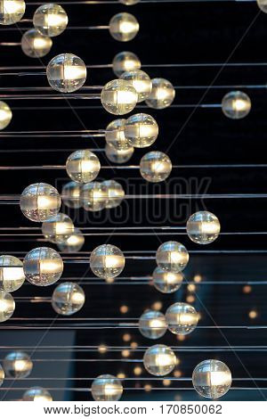 lighting balls on the chandelier in the lamplight light bulbs hanging from the ceiling lamps on the dark background selective focus horizontal