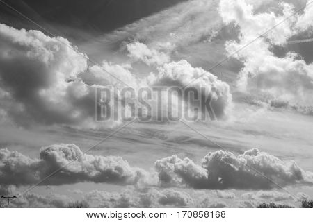 Netherlands -March, 2016 In the sky a bright ray of sunshine pierced the group of clouds, animated clouds sunbeam, life in the sky, black and white