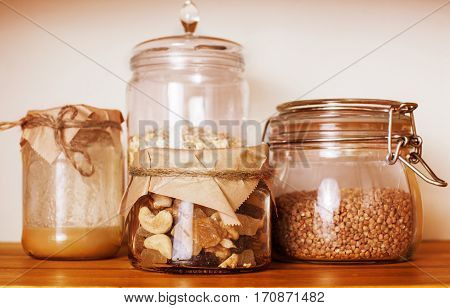 real comfort wooden kitchen with breakfast ingredients close up in glass, honey, oatmeal, milk, muesli, morning food