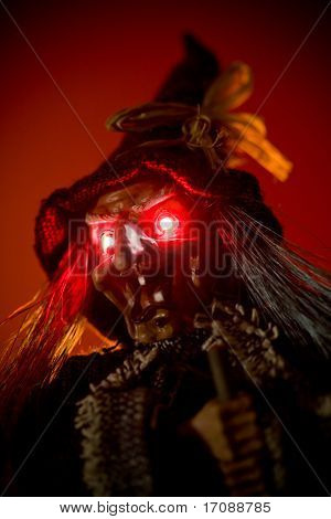 marionetta strega con occhi rossi luminosi su sfondo rosso