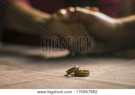 Love, Valentine`s Day And Wedding Concept. Two Wedding Rings With Man And Woman Hands Blurred In The