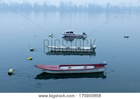 Small boats on the Danube on a foggy dusk in winter in Zemun Belgrade Serbia