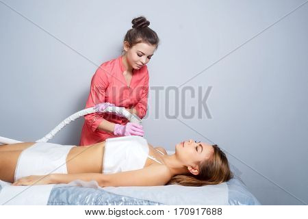 Vacuum massage the body of a young girl. Hardware cosmetology. Spa Studio. Rejuvenation and skin tightening. Anti-cellulite massage.