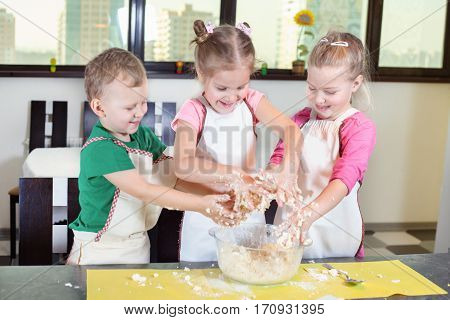 Three Lovely Children Preparing A Cake