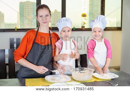 Two Lovely Children Together With Mother Preparing A Cake