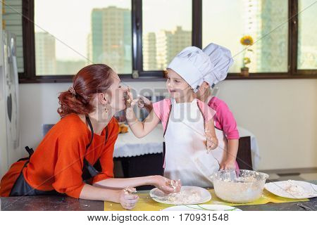 Two Lovely Children Together With Mother Preparing A Cake