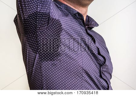 Young man with sweating under armpit at work