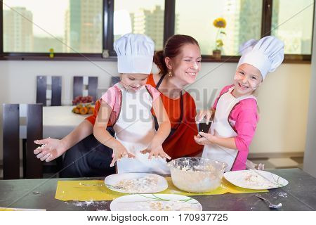 Two Lovely Children Together With Mother Preparing A Cake
