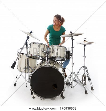 brunette brazilian woman has fun playing the drums in studio against white background