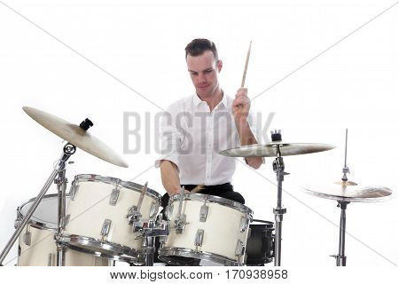 white drummer behind drum set wears white shirt and plays the drums in studio