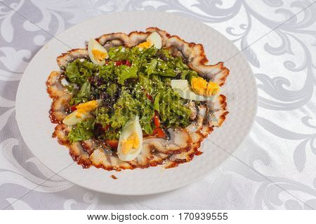 Salad with eel and vegetables. Very tasty food on a light background.