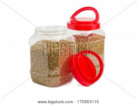 Buckwheat groats peeled from the husk in two transparent plastic containers with the red covers one of them open on a light background