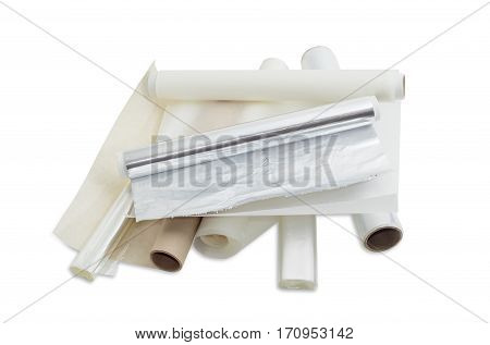 Several rolls of the plastic oven bags plastic food wrap aluminum foil and various parchment paper for household use on a light background.