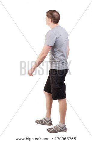 Back view of walking handsome man in shorts and sneakers.   Sports-dressed young man moves. going young guy. Rear view people collection. 