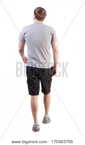 Back view of walking handsome man in shorts and sneakers.   Sports-dressed young man moves. going young guy. Rear view people collection.  backside view of person.  