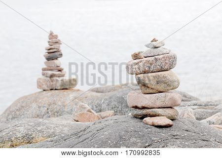 Two piles of stones on the rock the sea in the background. Short depth of focus
