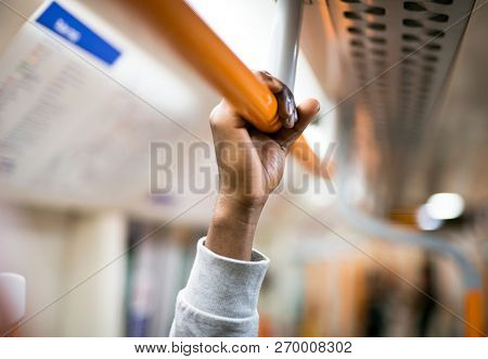 Man holding on to a handrail on a train