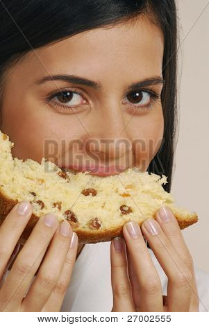 Giovane donna mangiare un pane fresco. Giovane donna di mangiare il panettone.